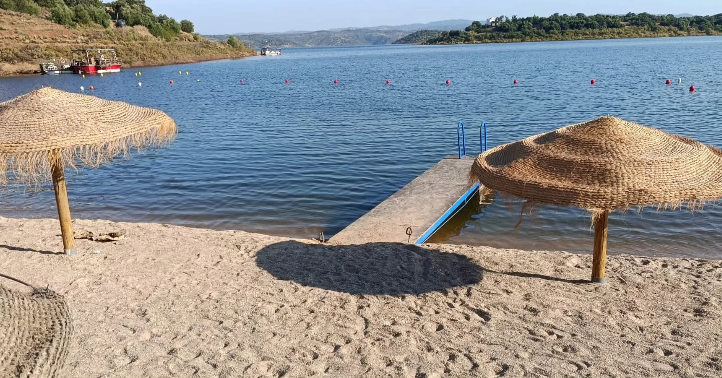 Playa interior del embalse de La Breña con sombrillas